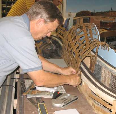 Mike Kremheller installing cardboard lattice for the foundation of a mountain going in on the layout of APN