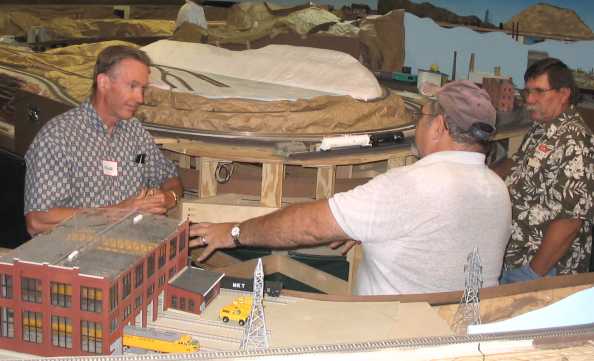 Chalie Richmond having an animated discussion with Roger and Johnnie in front of his diesel shop